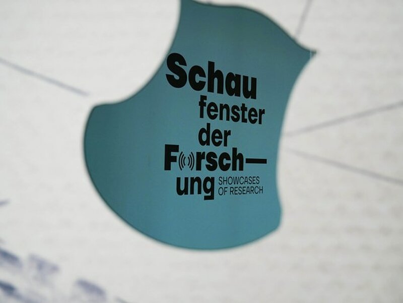 White background, center blue written 'Schaufenster der Forschung' and 'showcases of research'