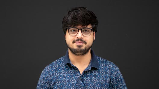 Portrait of Sukanta in front of an anthracite wall