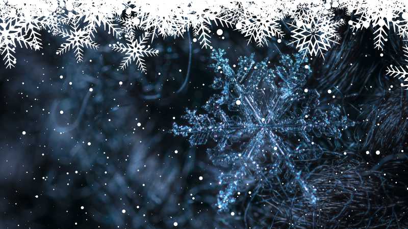 A dark blue-ish image with a large snow crystal and snow in the front