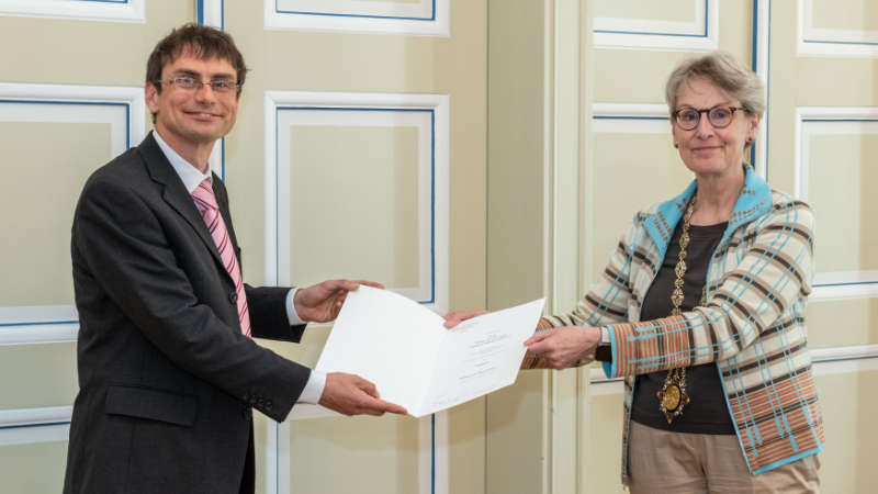 Prof. Ursula M. Staudinger, Rector of TU Dresden, hands over the certificate of appointment to Prof. Benjamin Friedrich.