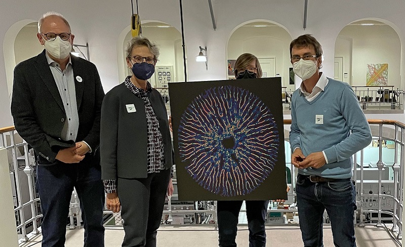 This photo shows, how the rector of TU Dresden, Prof. Staudinger, receives a print of a diatom biomineral network taken by predoc Iaroslav Babenko at the opening of the cfaed exhibition 'Imaging Science'. © Gwendolin Kremer, cfaed/Kustodie TU Dresden